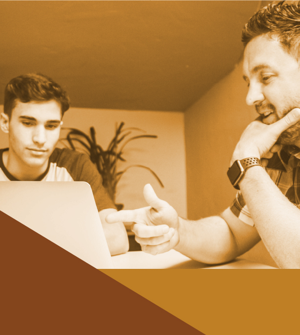 Two men working at a laptop.