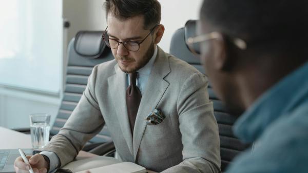 A specialist technology recruiter meticulously reviewing candidate documentation to verify technical experience and professional credentials.