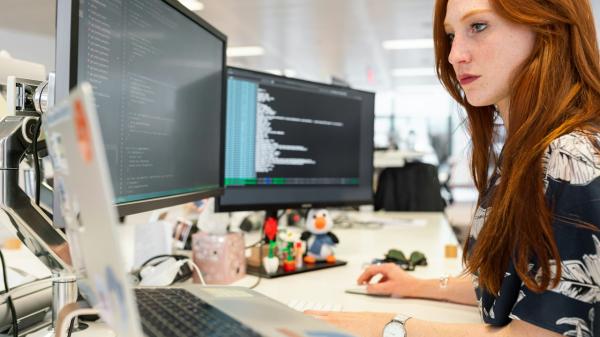 Developer working at a desk with code on screen