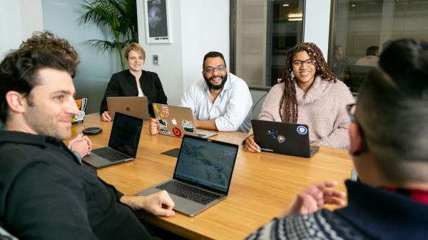 Team meeting around a table with laptops