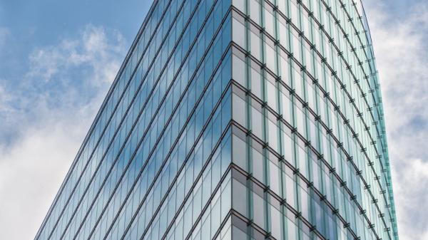 Glass office tower against a blue sky