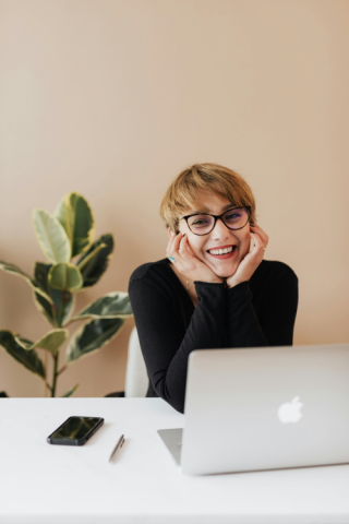 woman in front of a laptop smiling