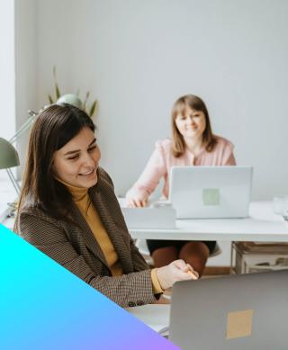 Two female IT recruiters in discussion looking at a laptop.