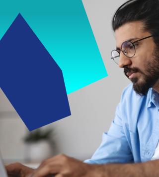 IT male professional sat at his desk working on a desktop.