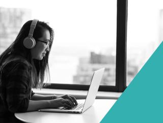 Black and white image of a female of a IT professional working on a desktop.