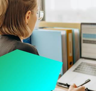 Professional female working on a laptop at a desk.