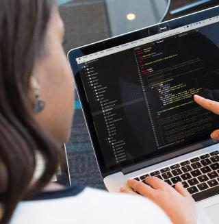 Professional female looking at a laptop screen.