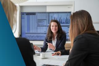 Team meeting with data insights dashboard shown on screen