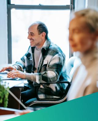 Smiling team member sat working at a computer
