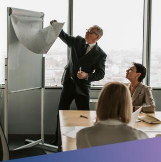 Team meeting with manager leading in front of flip chart