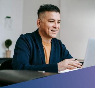 A man looking happily at his laptop