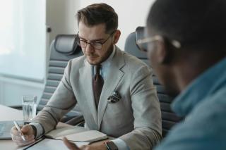 A specialist technology recruiter meticulously reviewing candidate documentation to verify technical experience and professional credentials.