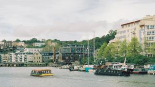 Boats moored on Bristol's Floating Harbour with harbourside apartments behind
