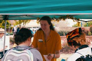 A charity volunteer helping visitors at a community information stall