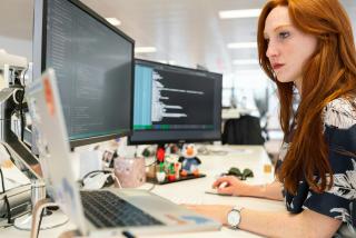 Developer working at a desk with code on screen