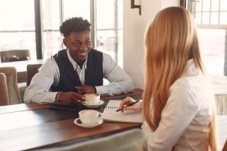 Two people chatting over coffee at a cafe table
