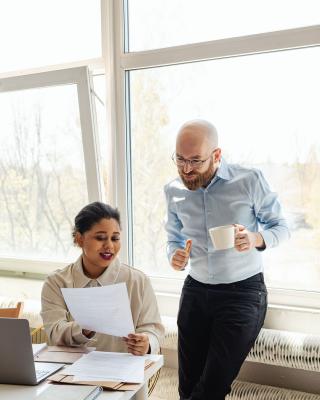 Two colleagues reviewing a document together in a bright office
