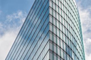 Glass office tower against a blue sky