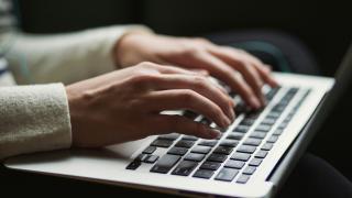 Female hands working on a laptop.