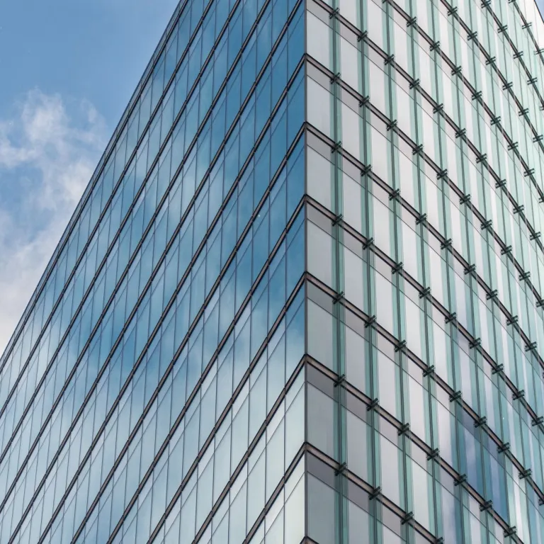 Glass office tower against a blue sky